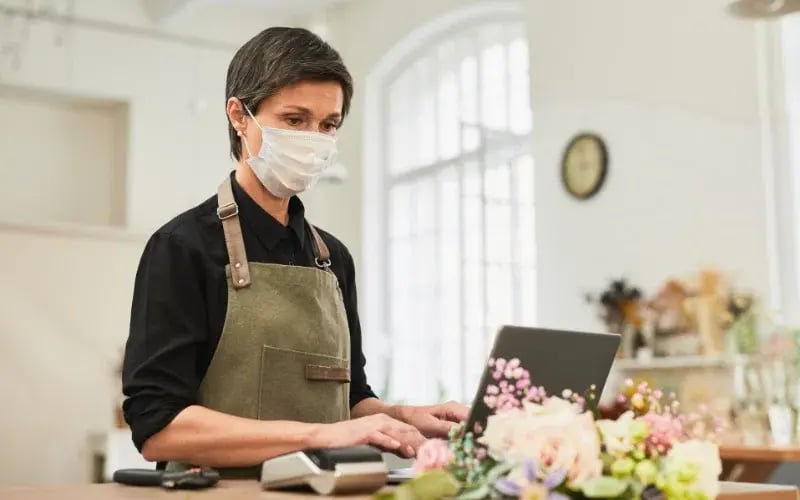 Small business owner wearing a mask in her shop